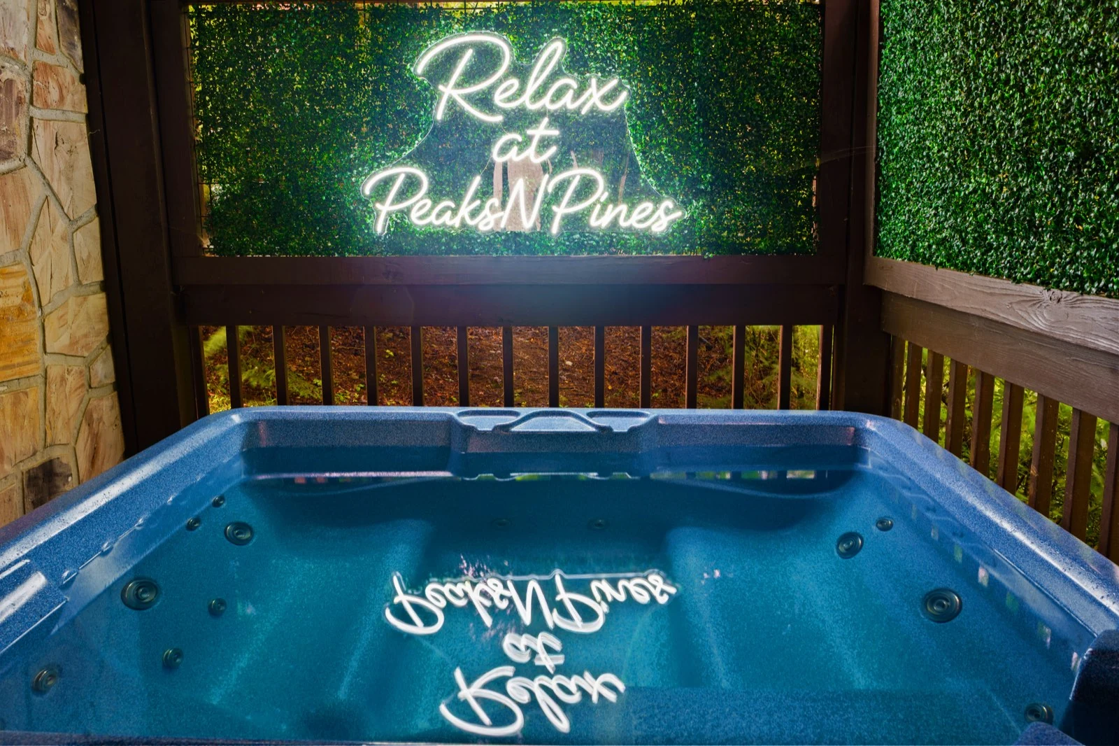 Private hot tub with visible water and the Relax at PeaksNPines sign